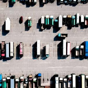 A photo showing an overhead view of trucks parked in a lot. : A freight broker can help you find low freight carrier rates.