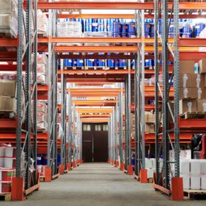 : A photo showing a person holding a clipboard next to stacks of boxes. Consolidated shipping can be more complex than ordinary shipping.